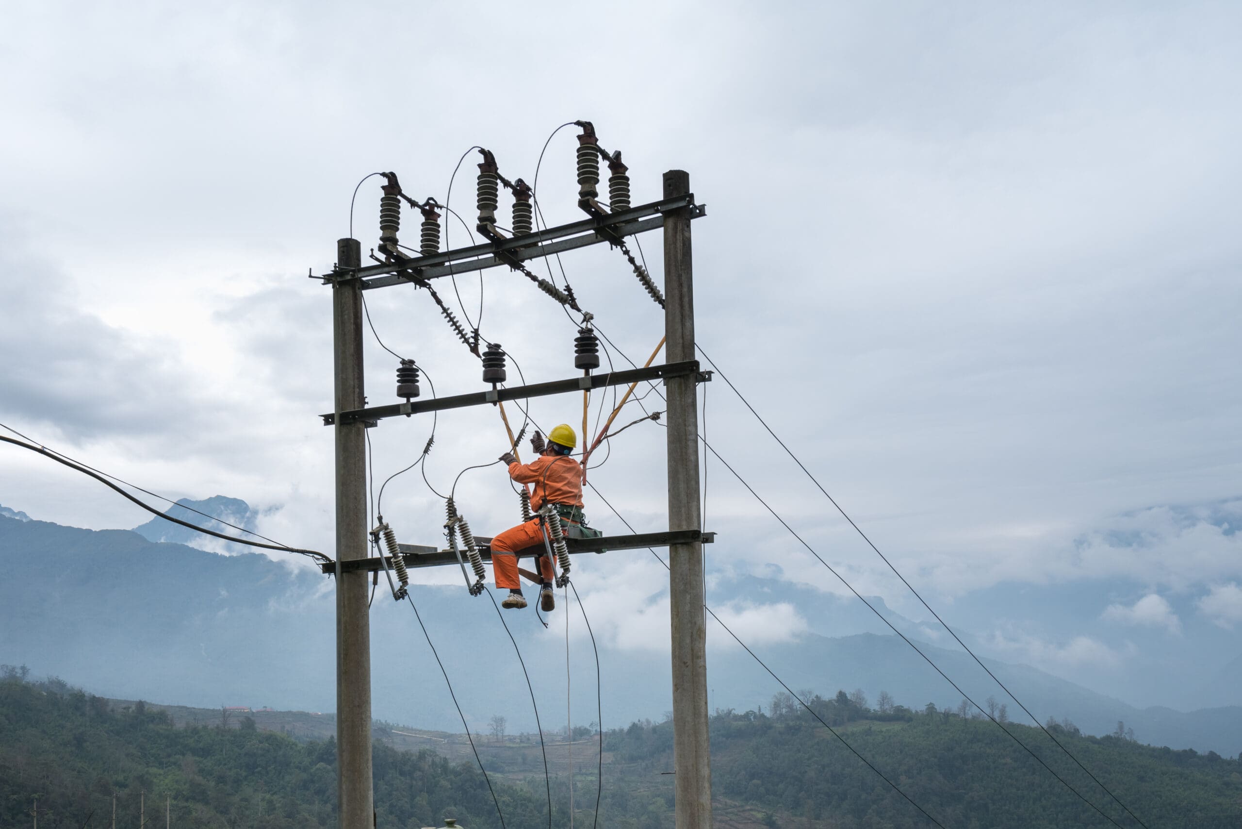 Electricians working on electricity pole