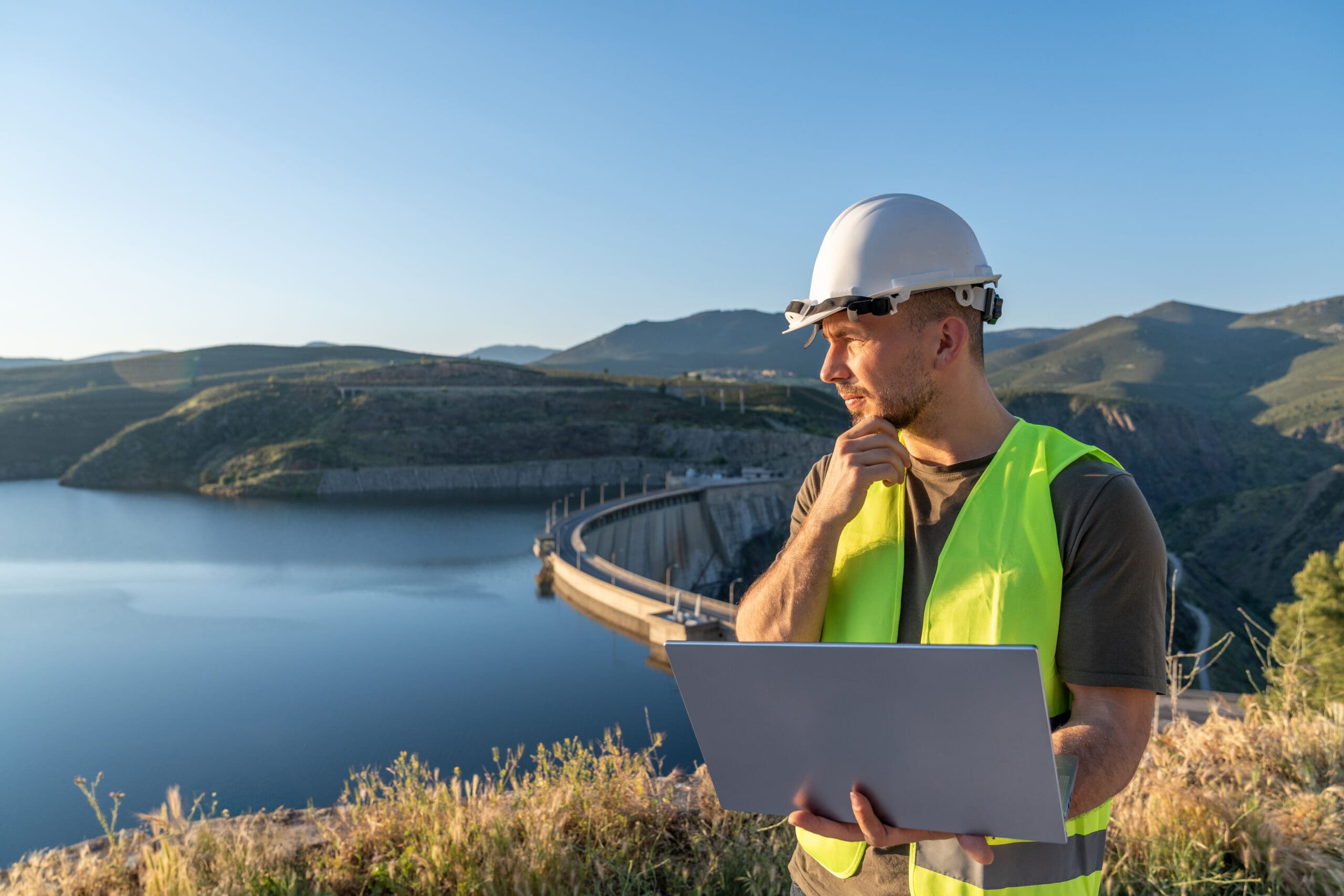 Inspecting dam with laptop for workplace safety